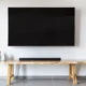 Barra de sonido para televisor colocada bajo una televisión en un salón moderno