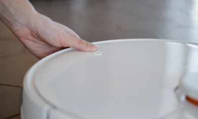 Aspirador robot con vapor: qué ofrece y cuándo merece la pena — primer plano de un aspirador robot liberando vapor mientras limpia el suelo de madera de una cocina moderna.