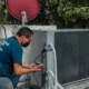 Técnico inspeccionando un aire acondicionado ante el código E2 error Midea aire acondicionado.