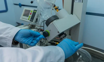 Técnico examinando las bobinas heladas de un frigorífico con el panel trasero abierto — imagen para Frigorífico no frost no enfría pero sí congela: causas reales y arreglo