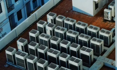 Técnico instalando un equipo de aire acondicionado en la azotea de un edificio residencial, ilustrando la Ley de propiedad horizontal y aire acondicionado en azotea.