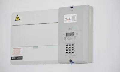 Técnico usando una pinza amperimétrica junto a un split de pared, imagen práctica sobre cuantos watts consume un aire acondicionado de 3000 frigorías inverter.