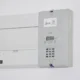 Técnico usando una pinza amperimétrica junto a un split de pared, imagen práctica sobre cuantos watts consume un aire acondicionado de 3000 frigorías inverter.