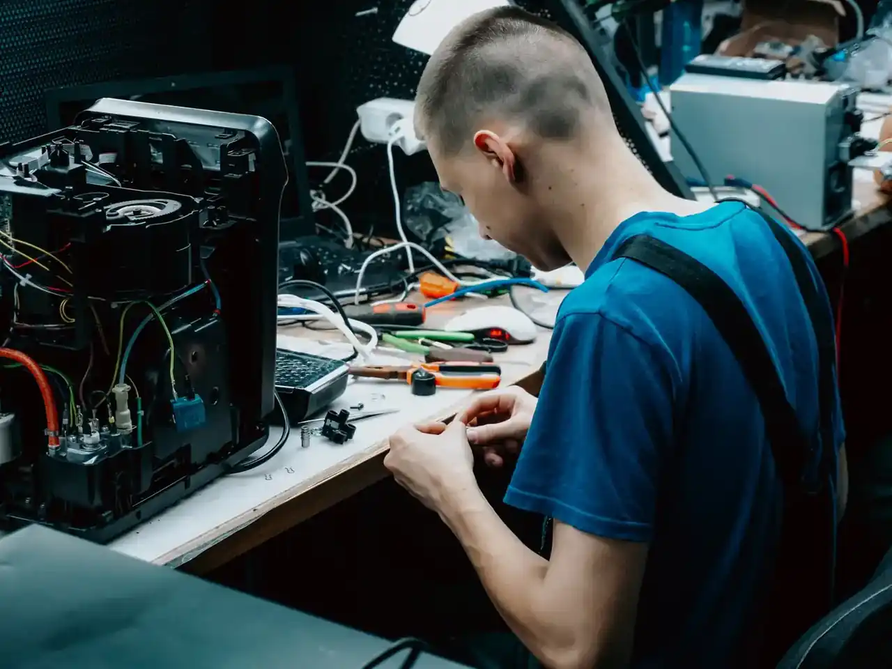 Técnico inspeccionando la placa y el panel de control de una lavadora Bosch Maxx 7 con un multímetro, imagen que ilustra Problemas de la lavadora Bosch Maxx 7 y cómo detectarlos.