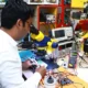 Técnico reparando una caldera con el panel abierto y un multímetro, imagen para ilustrar el artículo Fallo F13 en Saunier Duval: causas, señales y soluciones