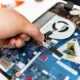 Técnico sosteniendo una placa electrónica mientras repara una caldera, imagen representativa de Caldera roca rs 20 20f: placa electrónica, fallo y recambio