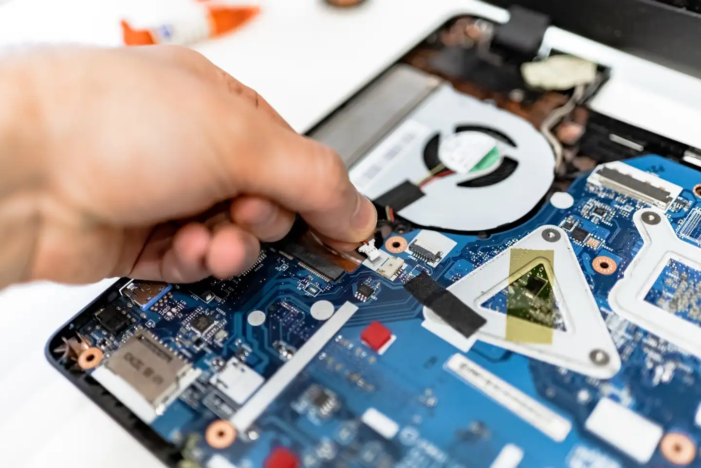 Técnico sosteniendo una placa electrónica mientras repara una caldera, imagen representativa de Caldera roca rs 20 20f: placa electrónica, fallo y recambio