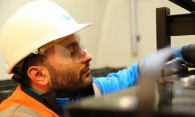 Técnico inspeccionando un vaso de expansión junto a una caldera doméstica, ilustración práctica — Vaso de expansión caldera: guía clara para elegir y detectar fallos