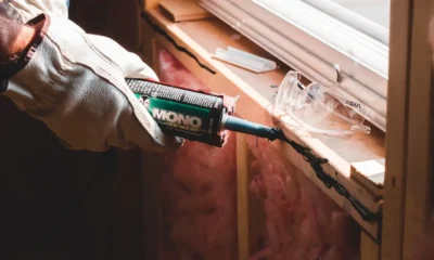 Técnico colocando un aire acondicionado en una ventana, imagen para Cómo instalar un aire acondicionado sin dañar la ventana que muestra fijación y sellado cuidadoso para no dañar el marco.