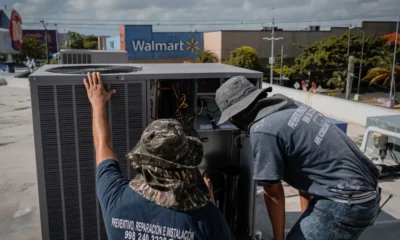 Técnico conectando una bomba de vacío a una unidad exterior de aire acondicionado, con manifold y manómetros visibles — imagen para el artículo 'Bomba de vacio aire acondicionado: cómo elegir y usarla bien'.