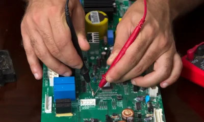 Técnico comprobando con un multímetro una placa electrónica de caldera en primer plano — Placa electrónica de caldera: guía útil para elegir y detectar fallos