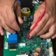 Técnico comprobando con un multímetro una placa electrónica de caldera en primer plano — Placa electrónica de caldera: guía útil para elegir y detectar fallos