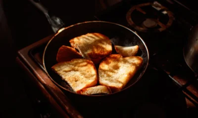 Persona tostando pan en una sartén en la cocina, imagen para explicar como tostar pan sin tostadora.