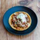Tostadora minimalista y compacta sobre una encimera de cocina moderna con tostadas y una taza de café; Lidl presenta su nueva tostadora minimalista y compacta en un ambiente de desayuno contemporáneo.
