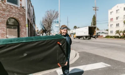 Dos personas moviendo un frigorífico en una mudanza, ilustrando que se puede transportar un frigorífico tumbado con precauciones.