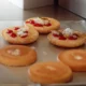 Tostadora vertical para pan de hamburguesa: cómo elegirla — primer plano de una tostadora vertical de acero inoxidable con panes de hamburguesa con sésamo en una cocina profesional mientras un cocinero coloca los panes.