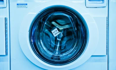 Técnico reparando una lavadora para Prolongar vida útil lavadora, imagen clara de mantenimiento del hogar