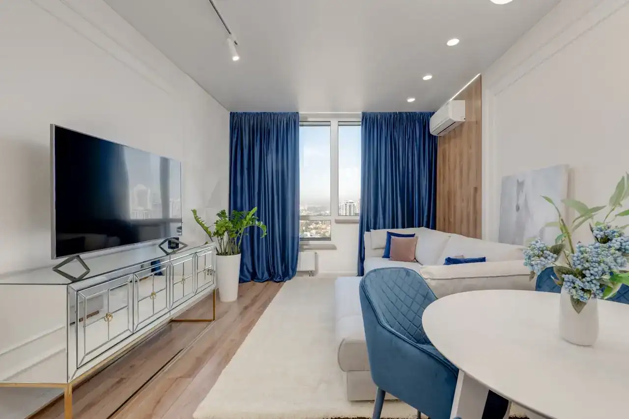 Aire acondicionado portátil Beko BA312C junto a una ventana en un salón