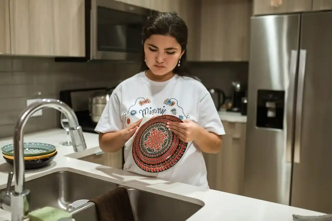 Persona cargando un lavavajillas de acero inoxidable en una cocina moderna, imagen para el artículo Cuál es el mejor lavavajillas: guía completa para acertar.