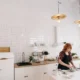 Frigorífico con pantalla táctil en la puerta: modelos y claves — persona tocando la pantalla de un frigorífico inteligente de acero inoxidable en una cocina moderna, con frutas y utensilios en la encimera.