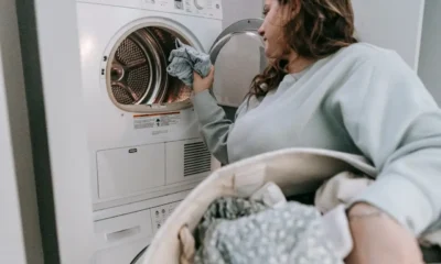 Mujer usando el móvil junto a una lavadora de carga frontal en una escena sobre lavadora hisense connectlife opiniones